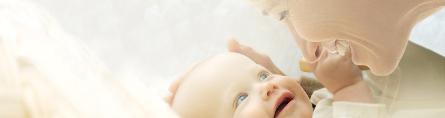 A woman and a baby are engaged in a close, intimate interaction.