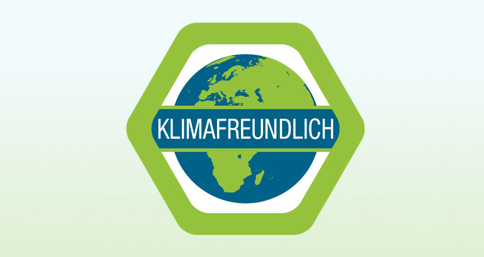 Een zeshoekige badge met een blauwe en groene wereldbol in het midden, met de witte tekst "KLIMAFREUNDLICH" in het midden.