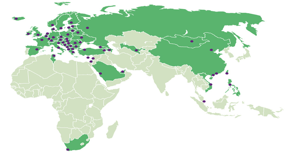 Een kaart van de wereld met groene gebieden, paarse stippen en een windroos.