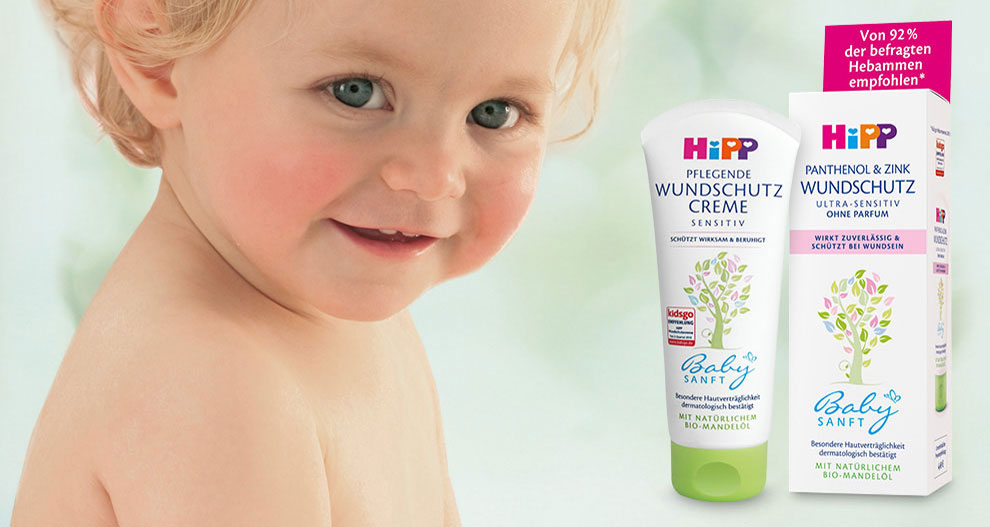 Een jong kind staat naast een tube "Hipp"-babycrème, die in het Duits "ultra-sensitiv" en "crème" wordt genoemd.