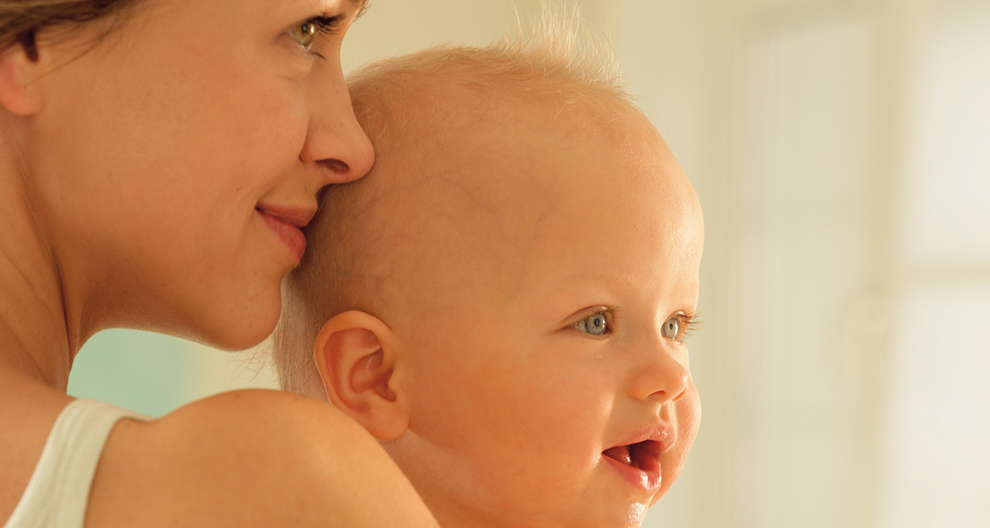 Een vrouw houdt een baby dicht bij haar gezicht.