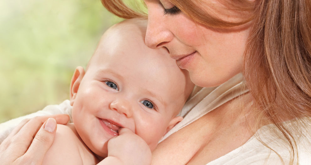 Een vrouw houdt liefdevol een baby vast.