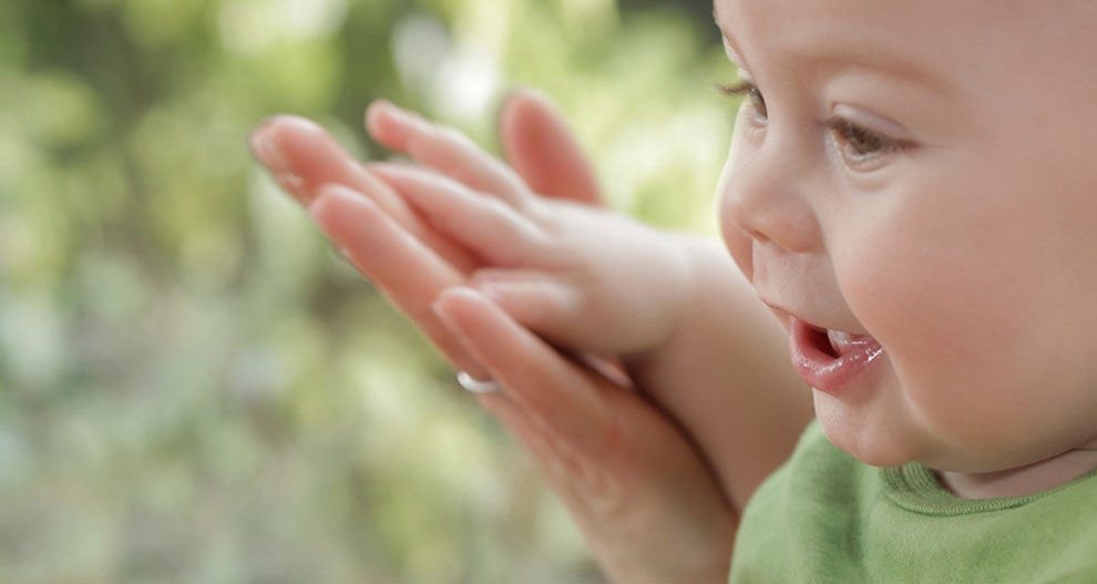 Een close-up van het gezicht van een baby, met een onscherpe achtergrond, die een moment van nieuwsgierigheid of verwondering vastlegt.