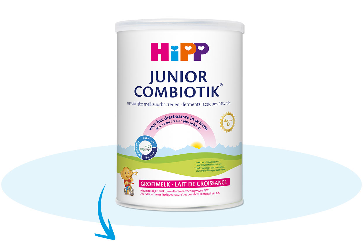 Een witte cilindrische verpakking met het label "Hipp Junior Combiotik" prominent bovenaan, vergezeld van een afbeelding van een kind en een landschapsillustratie.