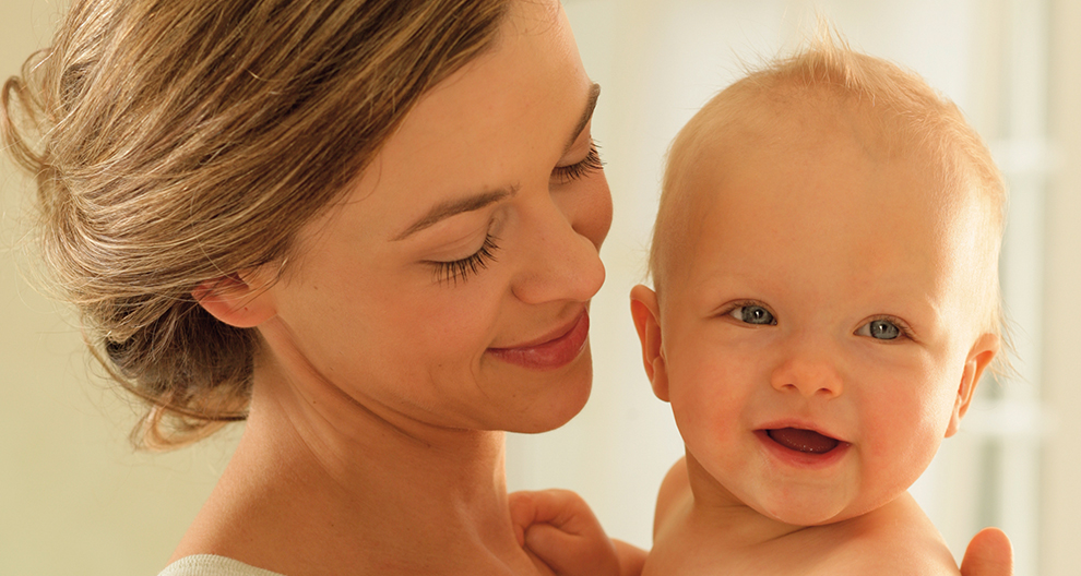 Een vrouw houdt een baby dicht bij haar gezicht.