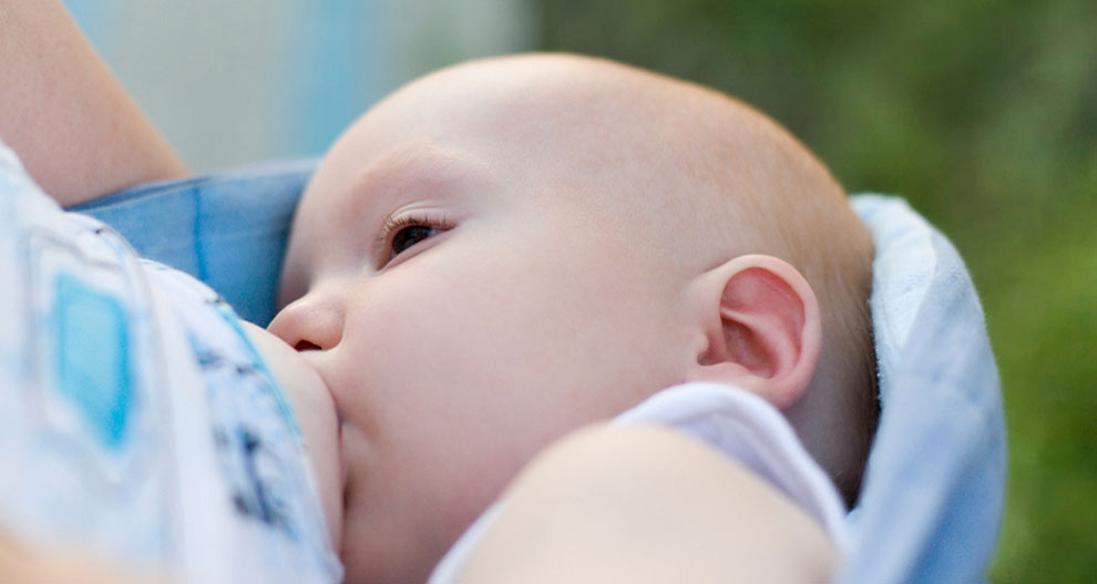 Een close-up van het gezicht van een baby, gedeeltelijk verborgen door een doek, met een onscherpe achtergrond.