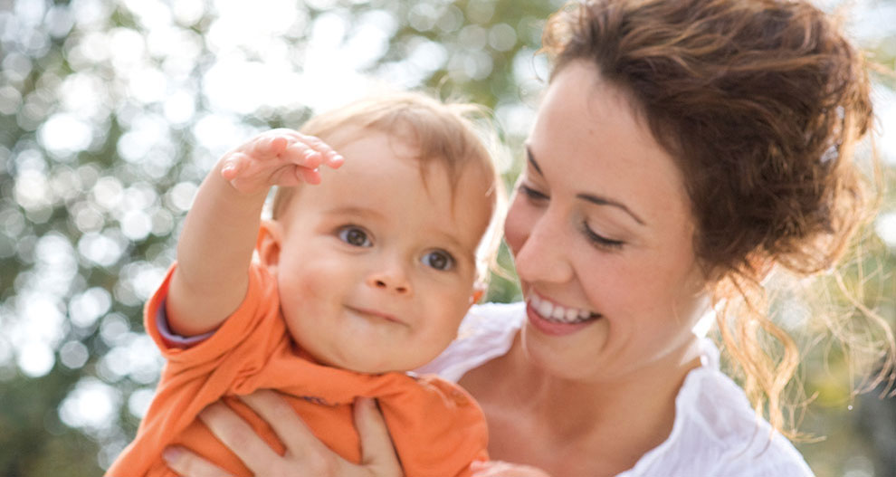 Een vrouw houdt buiten een baby vast.